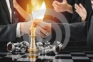 Double exposure image of business team work shaking hand while their colleagues applauding in meeting room office with chess board