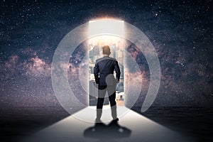 The double exposure image of the businessman standing front of the door is opening during sunrise overlay with cityscape and astro