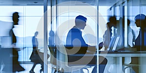 Double exposure image of businessman typing laptop, and fast moving business people at office