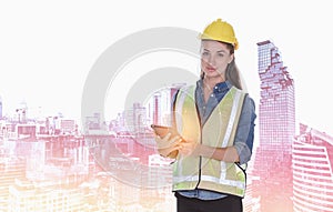 Double exposure image of female construction engineer holding tablet computer during overlay with construction site in the city