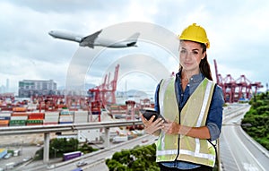 Double exposure image of female construction engineer in yellow safety helmet and holding tablet computer standing during overlay