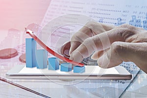 Double exposure of man finger using a phone with graph bar rows of coins book bank for finance and business concept