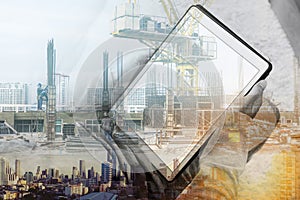 Double exposure, a man using digital tablet and buildings construction with cityscape