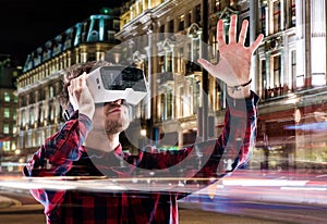Double exposure, man wearing virtual reality goggles, night city