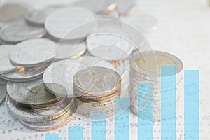 Double exposure of money coins stack with graph.