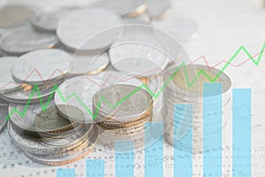 Double exposure of money coins stack with growing graph.