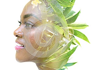 A double exposure portrait of a female model combined with an image of green leaves.