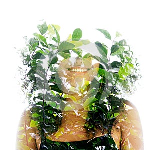 A double exposure portrait of a smiling woman merged with green leaves