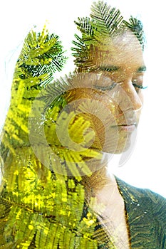 Double exposure portrait of a woman combined with green enlarged plant leaves
