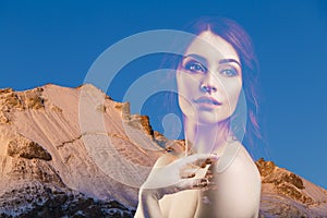 Double exposure portrait of young beautiful woman and mountains.