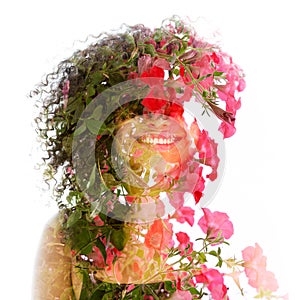 A double exposure portrait of a young smiling woman combined with pink flowers