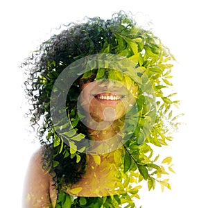 A double exposure portrait of a young woman with frizzy hair merged with leaves