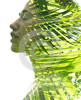 A double exposure portrait young woman profile with her eyes closed against white background and palm tree leaves