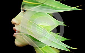 A double exposure portrait of a young woman's profile against black background with fresh green leaves
