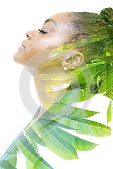 A double exposure profile portrait of a woman combined with foliage. Unity with nature.