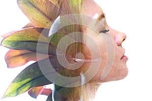 A double exposure profile portrait of a woman combined with an image of foliage.