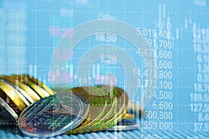 Double exposure stacks of coins with stock market board and financial graph for business and financial concept. shallow focus.