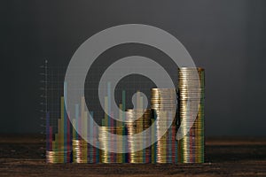 Double exposure step of coins stacks on wooden table with financial graph and copy space for business and financial concept.