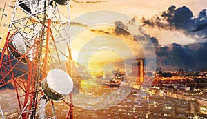 Double exposure telecommunication towers with TV antennas and satellite dish in sunset, with city background