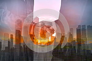 Double Exposure of Two Businessman shaking hand with City Building and Skyscraper as concept of Teamwork or Partnership business