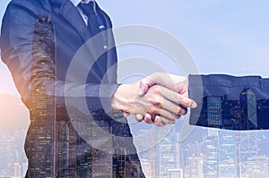 Double exposure of two businessmen shaking hands