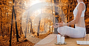 Double exposure of woman meditating in forest during autumn