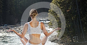 Double exposure of woman meditating on river at forest