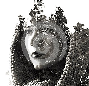 Double exposure of young beautiful girl among the leaves and trees. Portrait of attractive lady combined with photograph of tree.