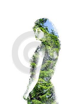 Double exposure of young beautiful girl among the leaves and trees. Portrait of attractive lady combined with photograph of tree.