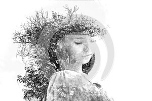 Double exposure of young beautiful girl among the leaves and trees. Portrait of attractive lady combined with photograph of tree.