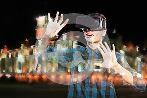 Double exposure of young man using VR headset glasses for virtual reality goggles