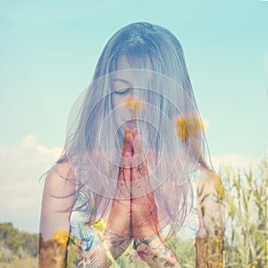 Double exposure of a young woman meditating and a peaceful lands