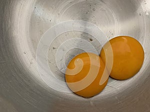 Double fresh egg yolks on stainless background, ingredients for dessert Landscape photo