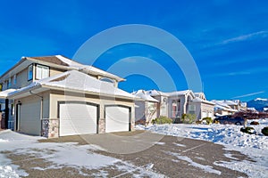 Double garage of big luxury house with driveway in snow