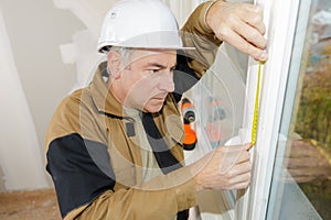 Double glazing installer measuring window