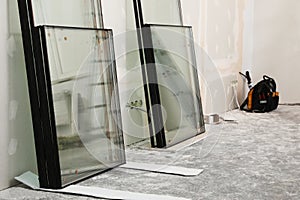 Double glazing windows on floor near plasterboard wall indoors