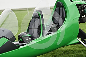 Two-seater green gyrocopter at the airfield photo