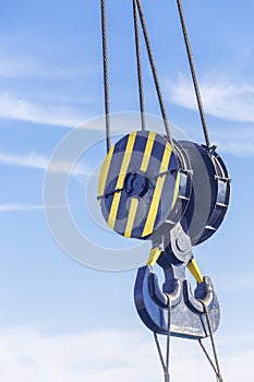 Double hook of a port crane close-up on a blue sky background