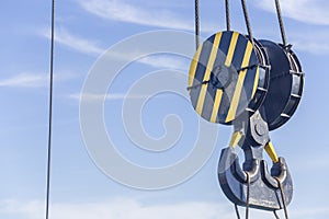 Double hook of a port crane close-up on a blue sky background