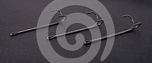 Double hooks for fishing of various sizes on a black background close-up