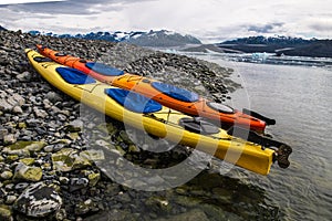 Double kayaks parked on the bay on scenic mountain ocean bay during arctic expedition.