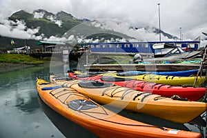 Double kayaks parked on the pier on scenic mountain ocean bay in Valdez, Alaska.