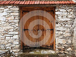 Double-leaf wooden door in a stone wall