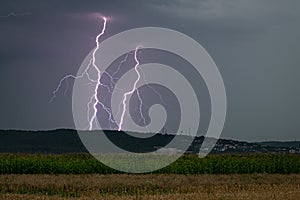 Double lightning strike just behind a hill