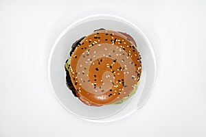 Double meat burger with vegetables on a white background. Delicious cheeseburger on a plate. Meat fast food. A large hamburger