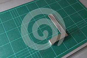 Metal angle square on green cutting mat background