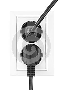 Double power European electric plug isolated on a white. Black electric cord plugged into a white electricity socket on white