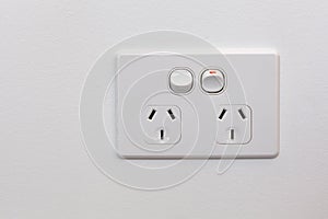 Double power outlet on white wall.
