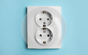 Double power socket on light blue wall. Electrical supply