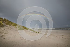 Double rainbow above the sea and beach.